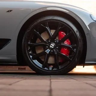 Bentley alloy wheel and red brake caliper cleaned by Porter's Car Detailing