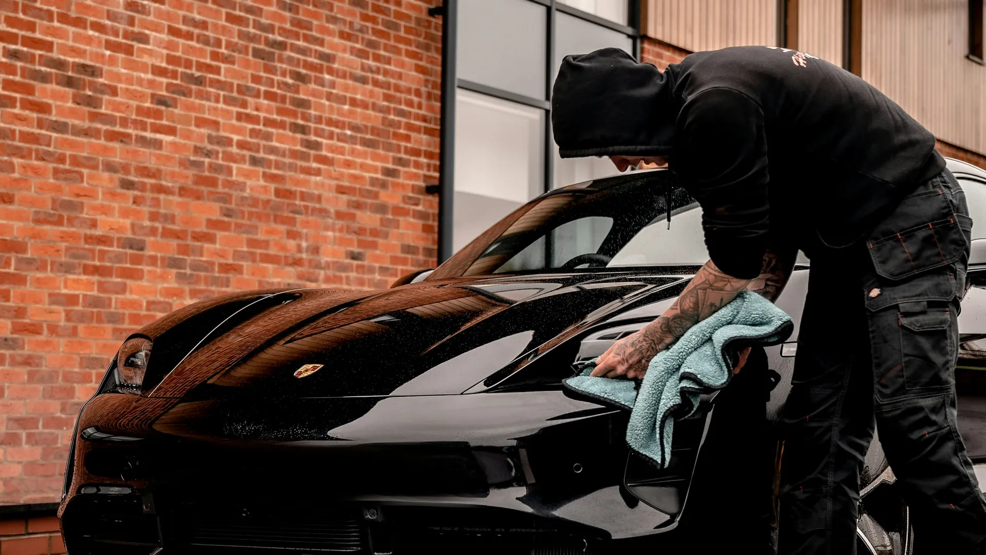 Detailer working on a black car in the studio Porter's Car Detailing Leicestershire